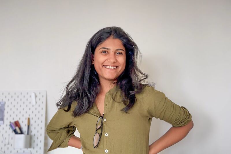 Simran, in a green shirt, hands on hips.